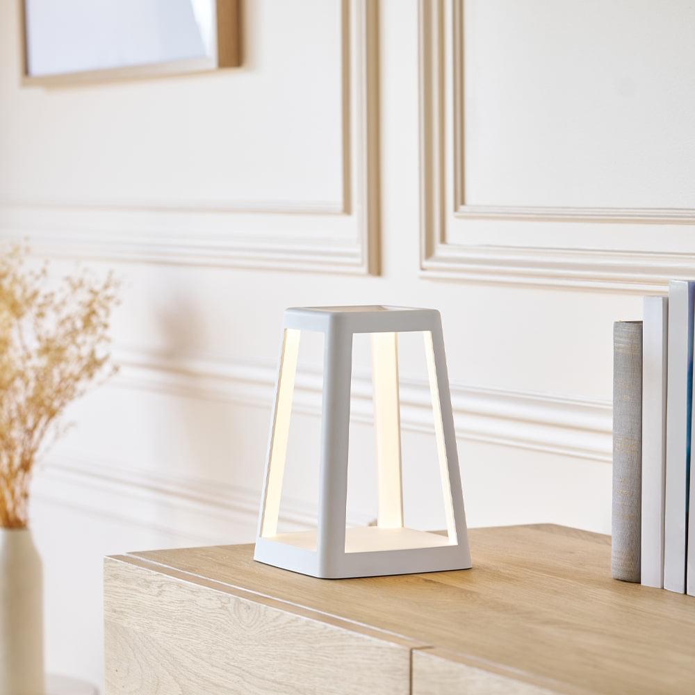 White portable lantern lamp on tabletop with open frame design