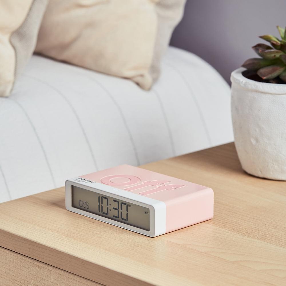 Rose pink desk alarm clock with flip cover on wooden table, showing time
