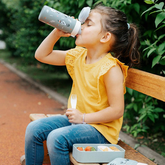 Insulated water bottle with green raccoon print being used for drinking