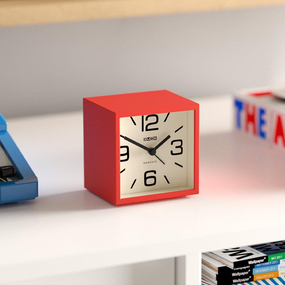 Fire engine red cube mantel clock with cream face, black hands and numbers on tabletop