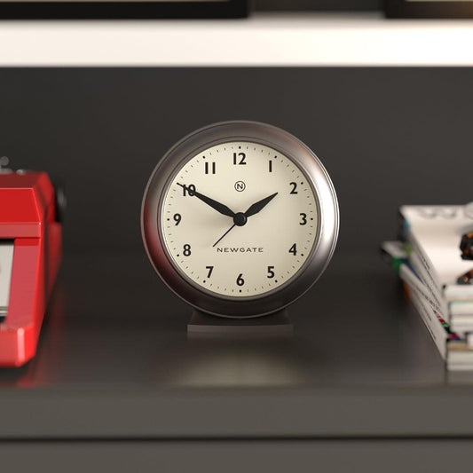 Graphite mantel clock on tabletop, cream face with black hour and minute hands