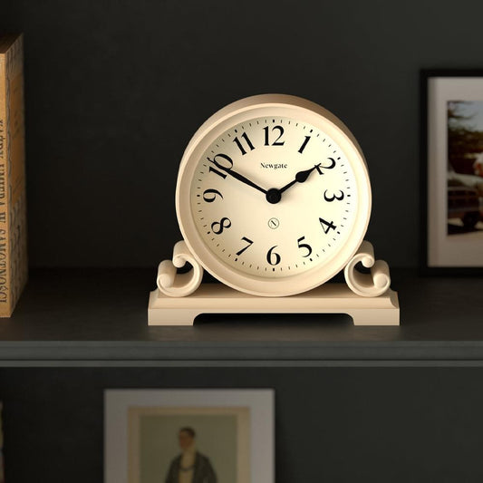 Vanilla cream mantel clock on shelf, round dial with black hands and numerals