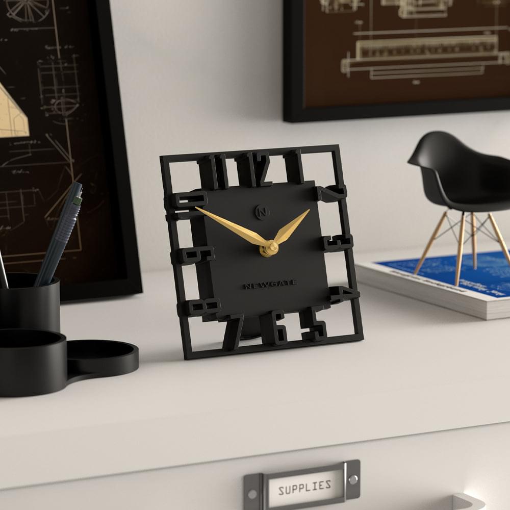 Black square mantel clock with gold hands, angled view