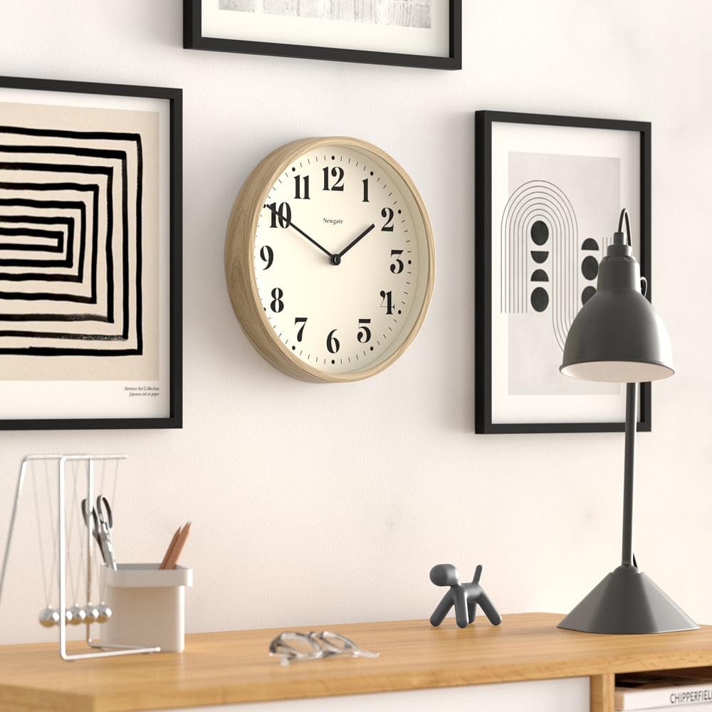 Wall clock with faux-wood frame and cream face, black numbers, and minute markers
