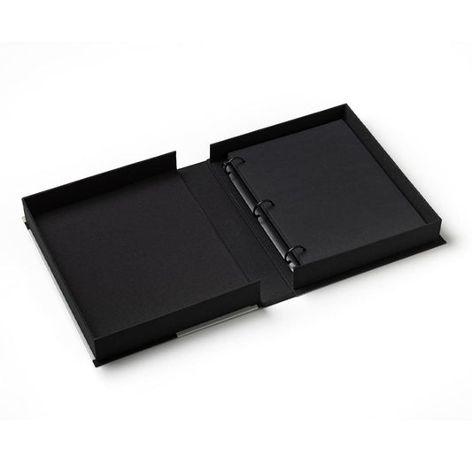 Black photo album opened, showing two black pages and a bound center spine