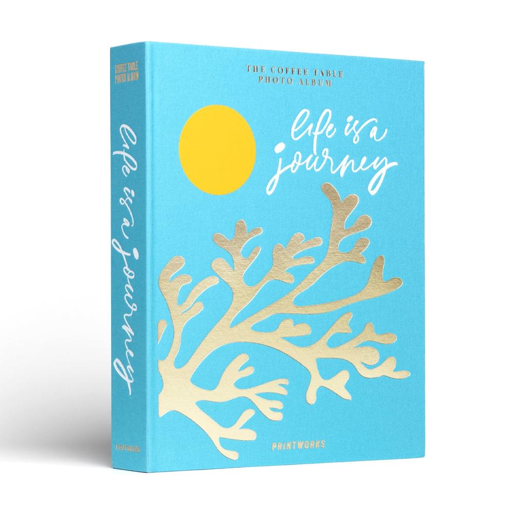 Turquoise photo album with spine text, yellow sun, and beige coral-tree cover art
