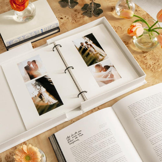 Wedding photo album open with four wedding photo prints in a ring binder layout