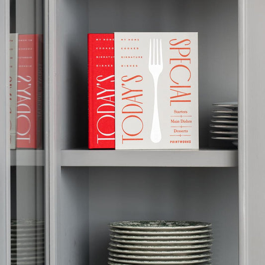 Recipe books in red and white with fork graphic spines on a shelf