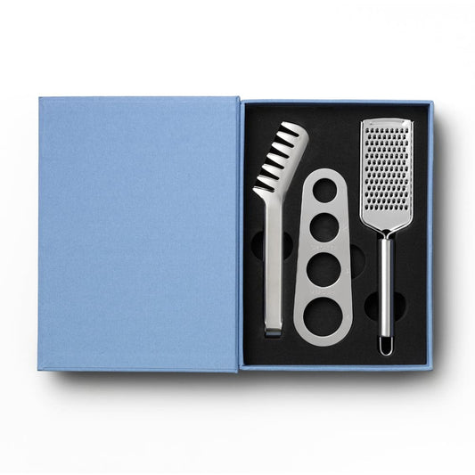 Open box showing stainless pasta tools: grater, ridged fork, and three-hole scoop