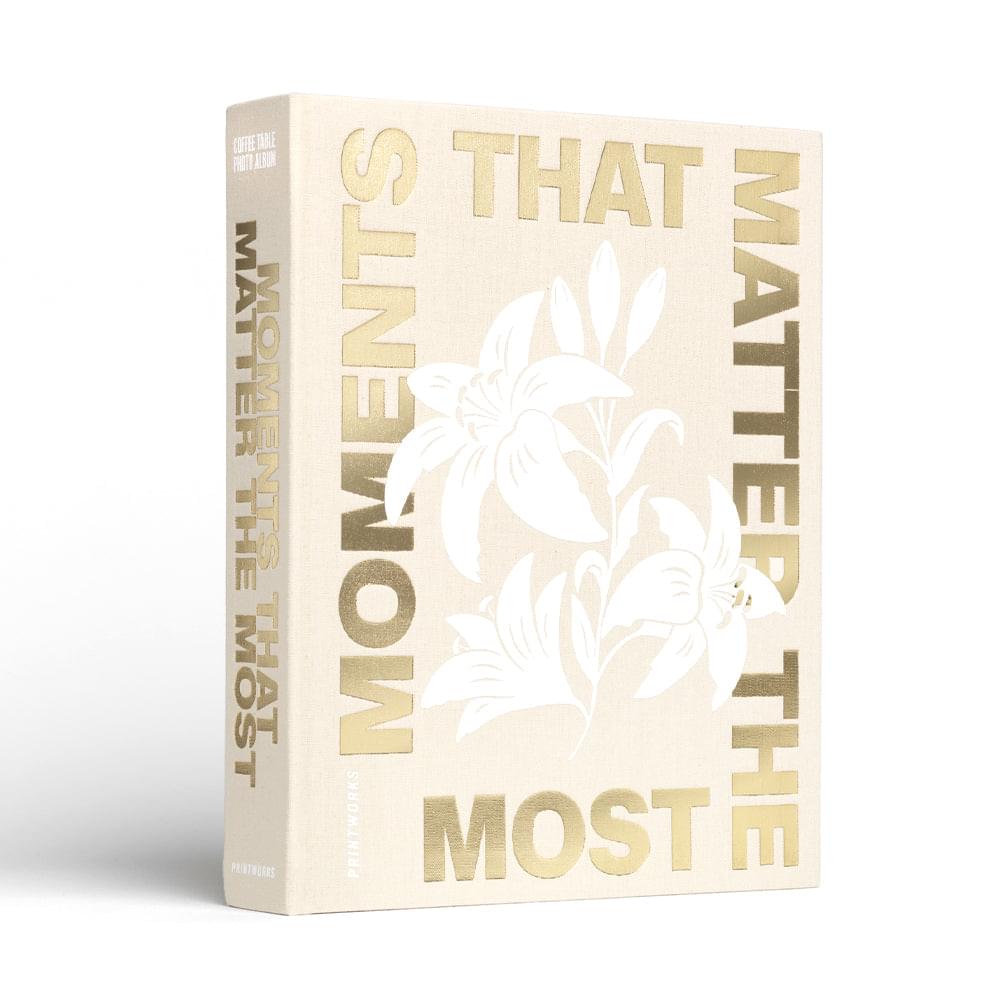 Beige hardcover photo album with white floral graphic and gold “MATTERS” lettering.