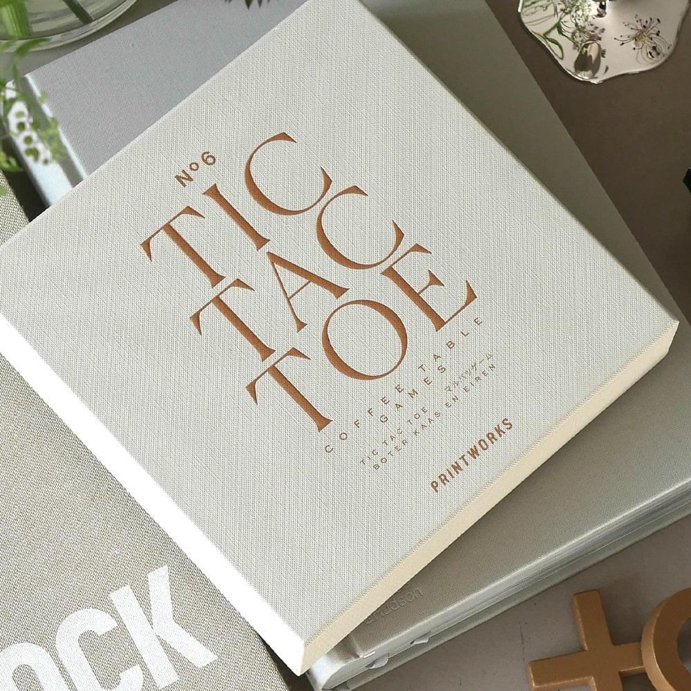 Beige game box lid with gold tic tac toe logo and PRINTWORKS mark