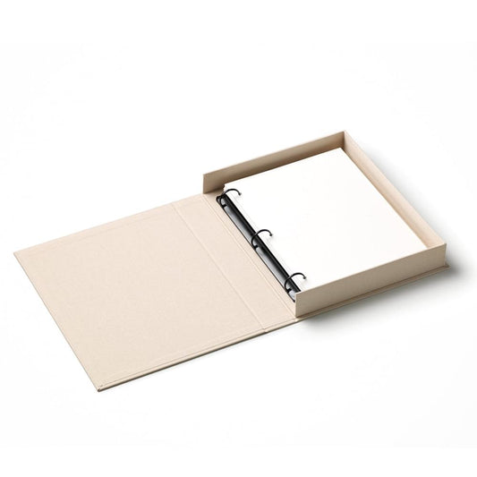 Beige photo album open with black binder rings and blank pages.
