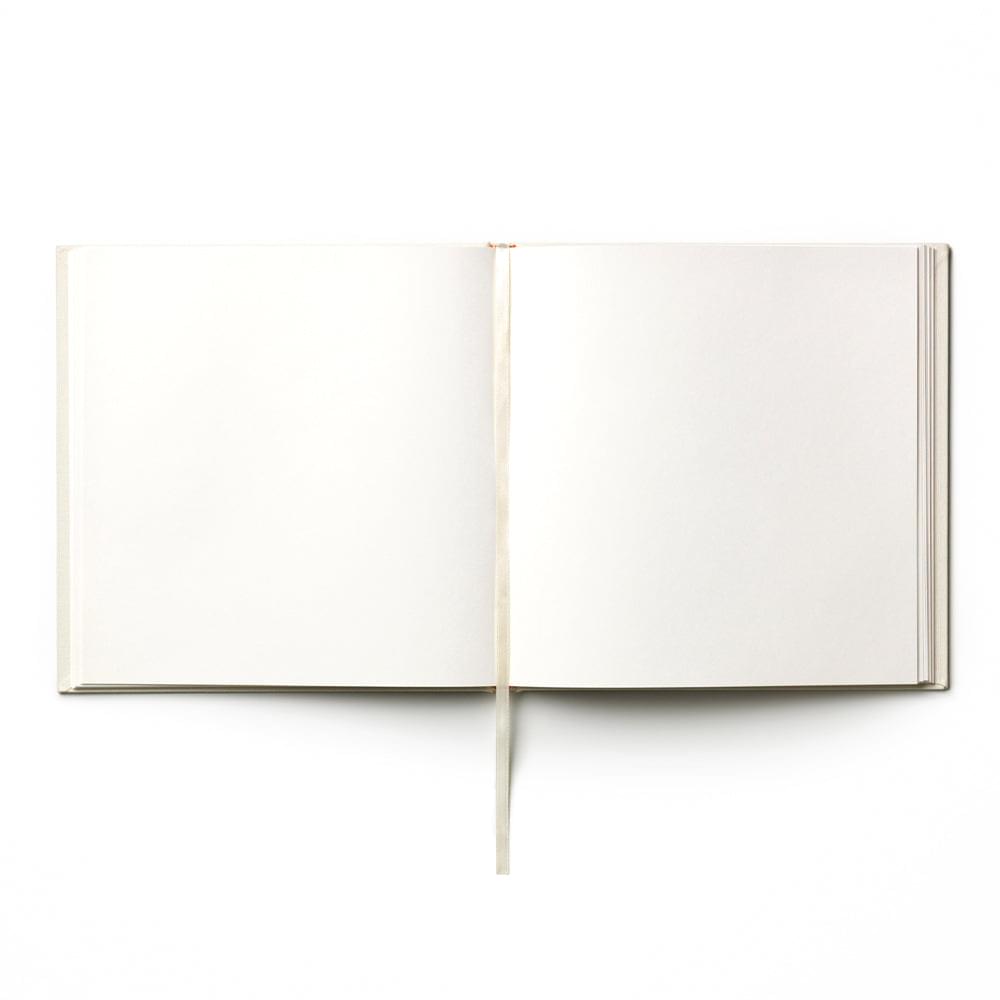 Open wedding guest book with two blank cream pages