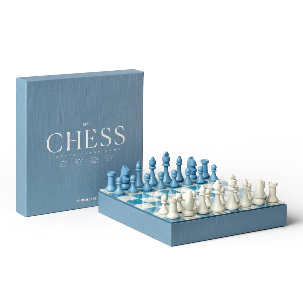 Dusty blue chess game box and open board with blue and white chess pieces