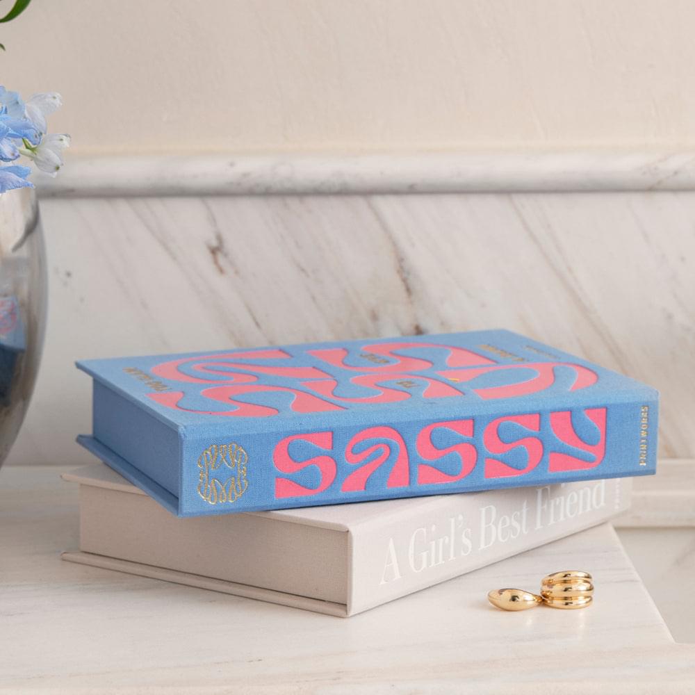 Blue book-style jewelry box with large pink lettering on the front
