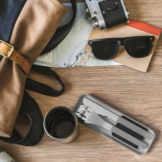 Three-piece stainless cutlery set with black-handled utensils in travel tray