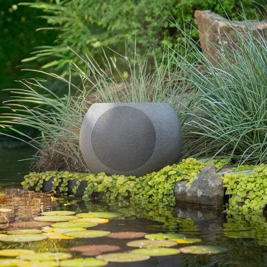 Stone-textured solar garden speaker with fabric grille on a rounded spherical body