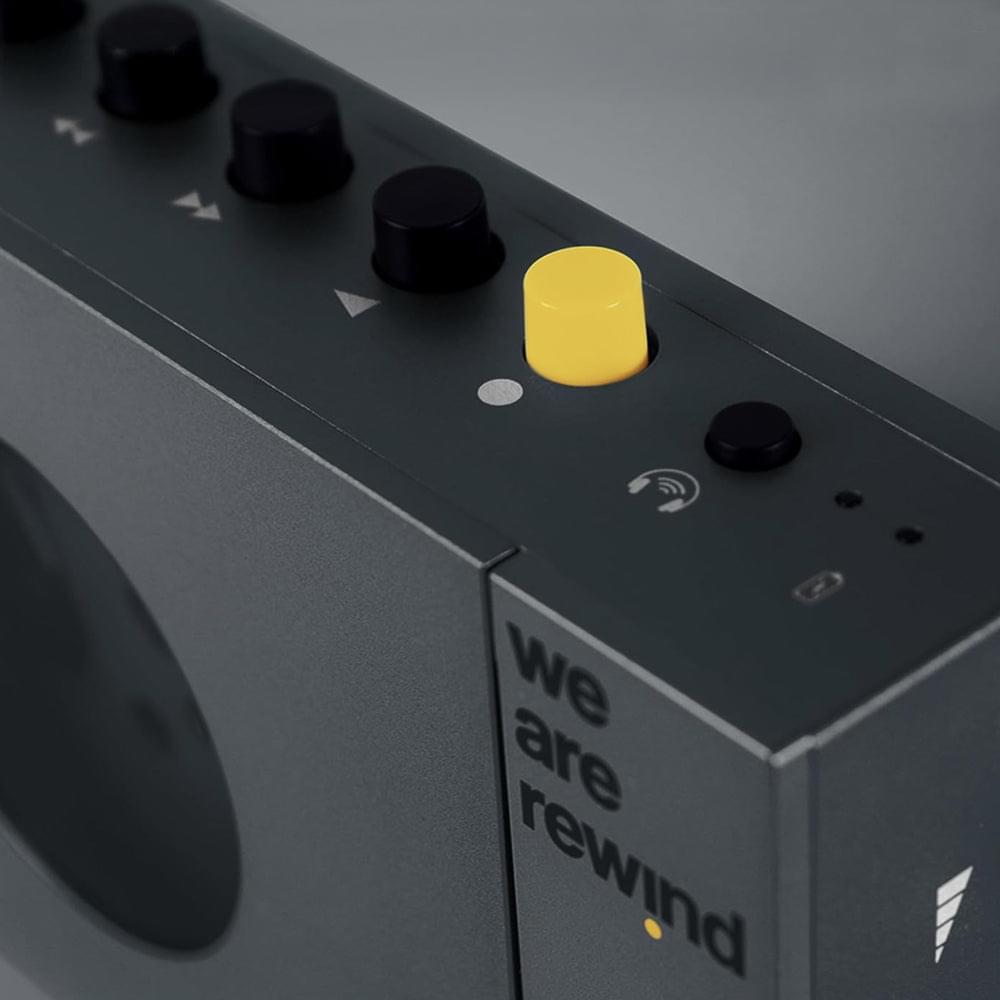 Grey portable cassette player/recorder with yellow button and black control knobs