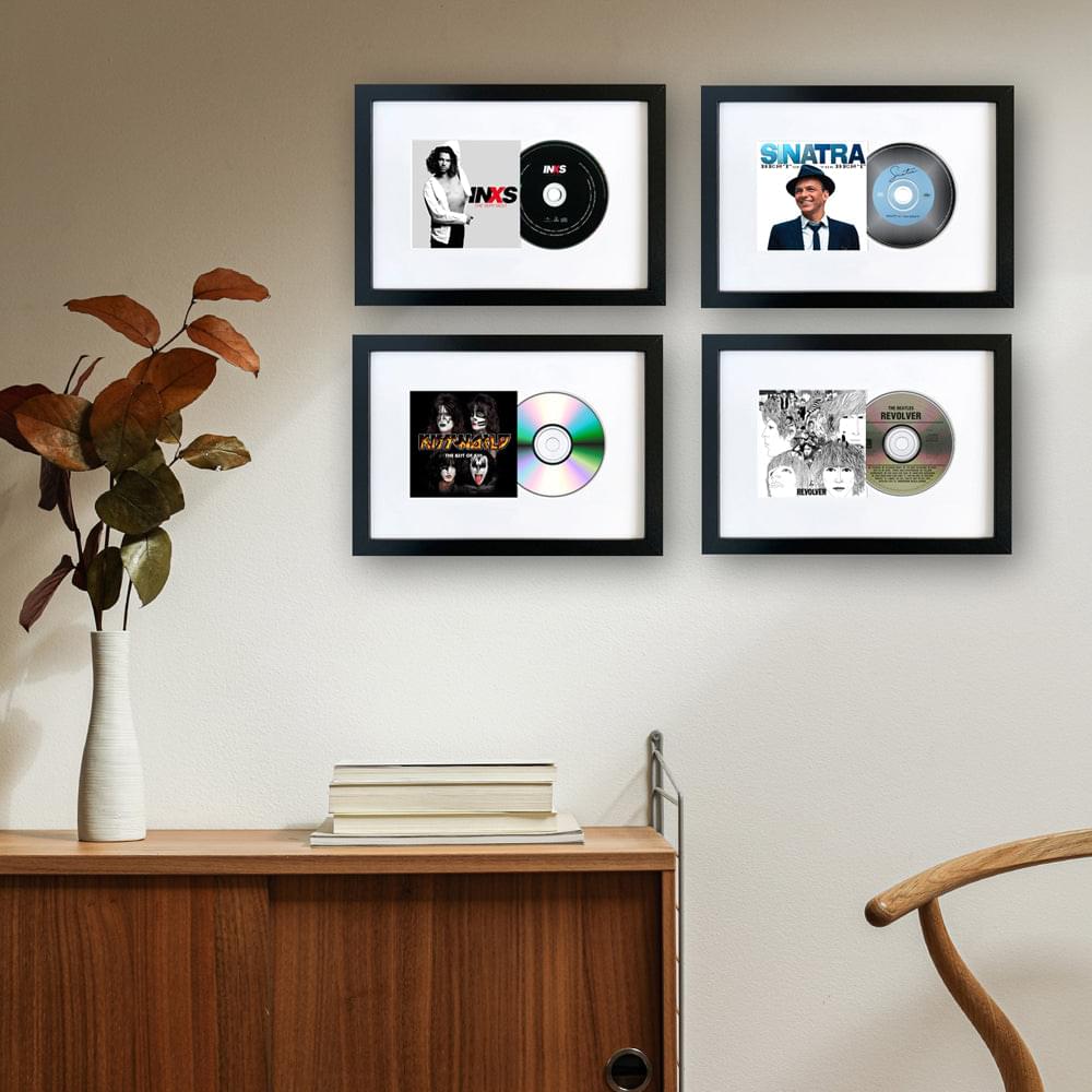 Four black-framed CD album art prints with record discs arranged in a grid