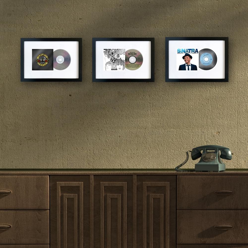 Three black-framed album CD art prints with circular discs and cover photos
