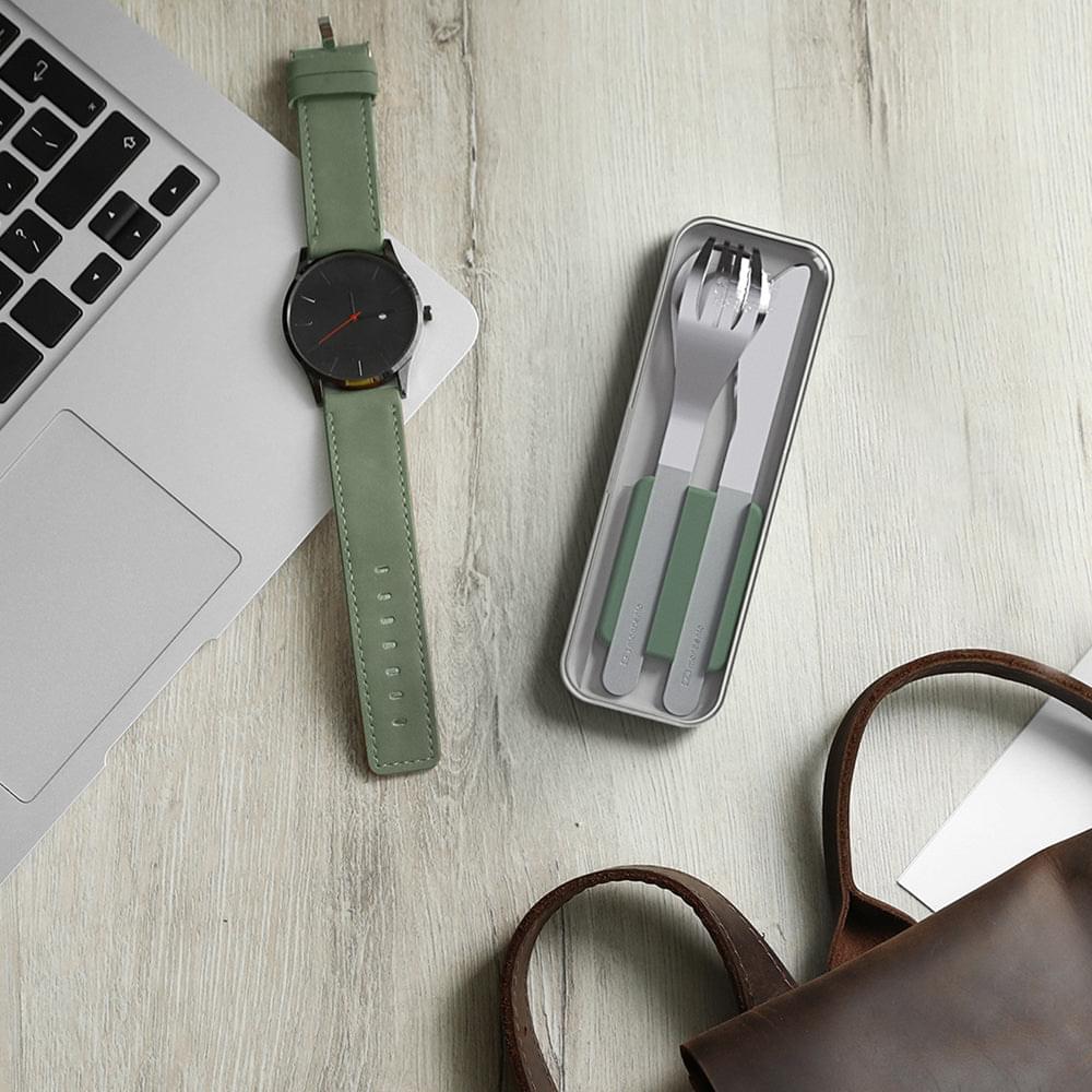 Trio knife set in slim case with green handles, on desktop