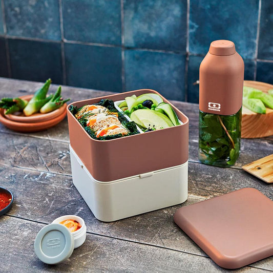 Square bento box with mauve lid and beige base, held shut with burgundy strap