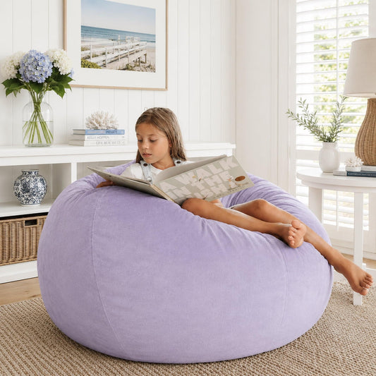 Lilac bean bag chair with stitched seams; child reclines while reading.