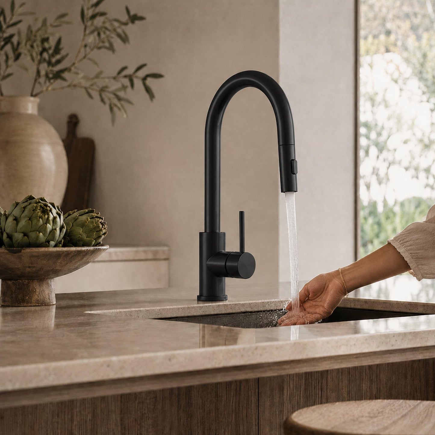 Matte black pull-out kitchen faucet with lever, hand turning water at sink
