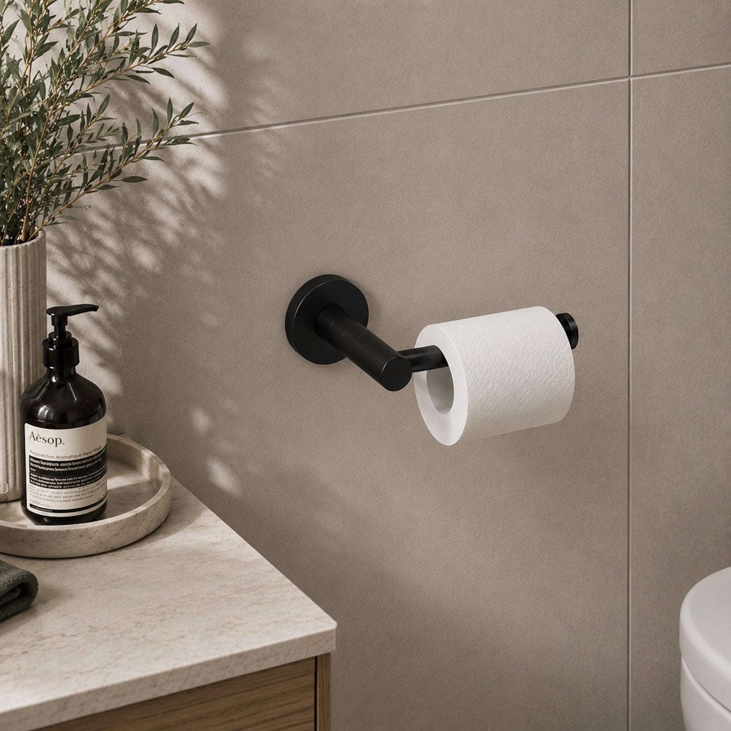 Matte black toilet roll holder with holder arm and roll on wall-mounted base