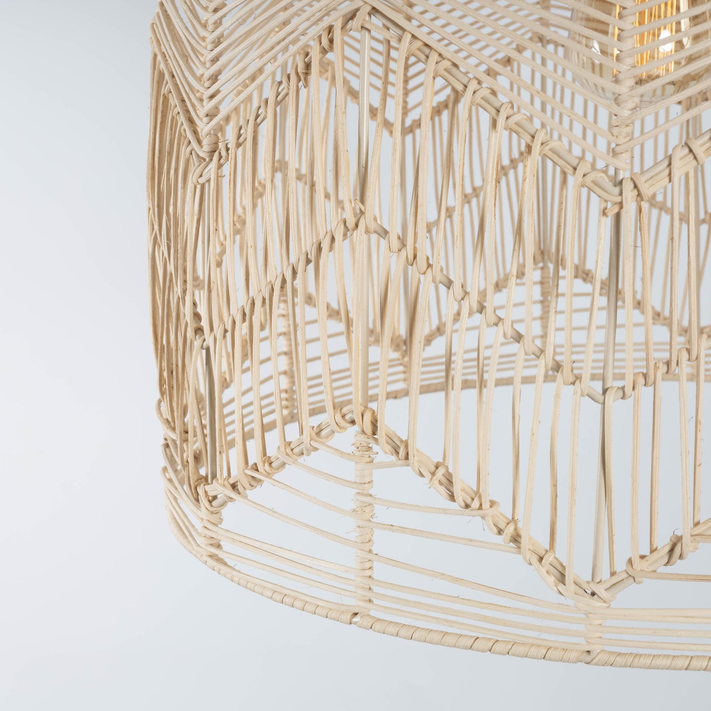 Close-up of natural rattan pendant shade underside with curved weave and vertical slats
