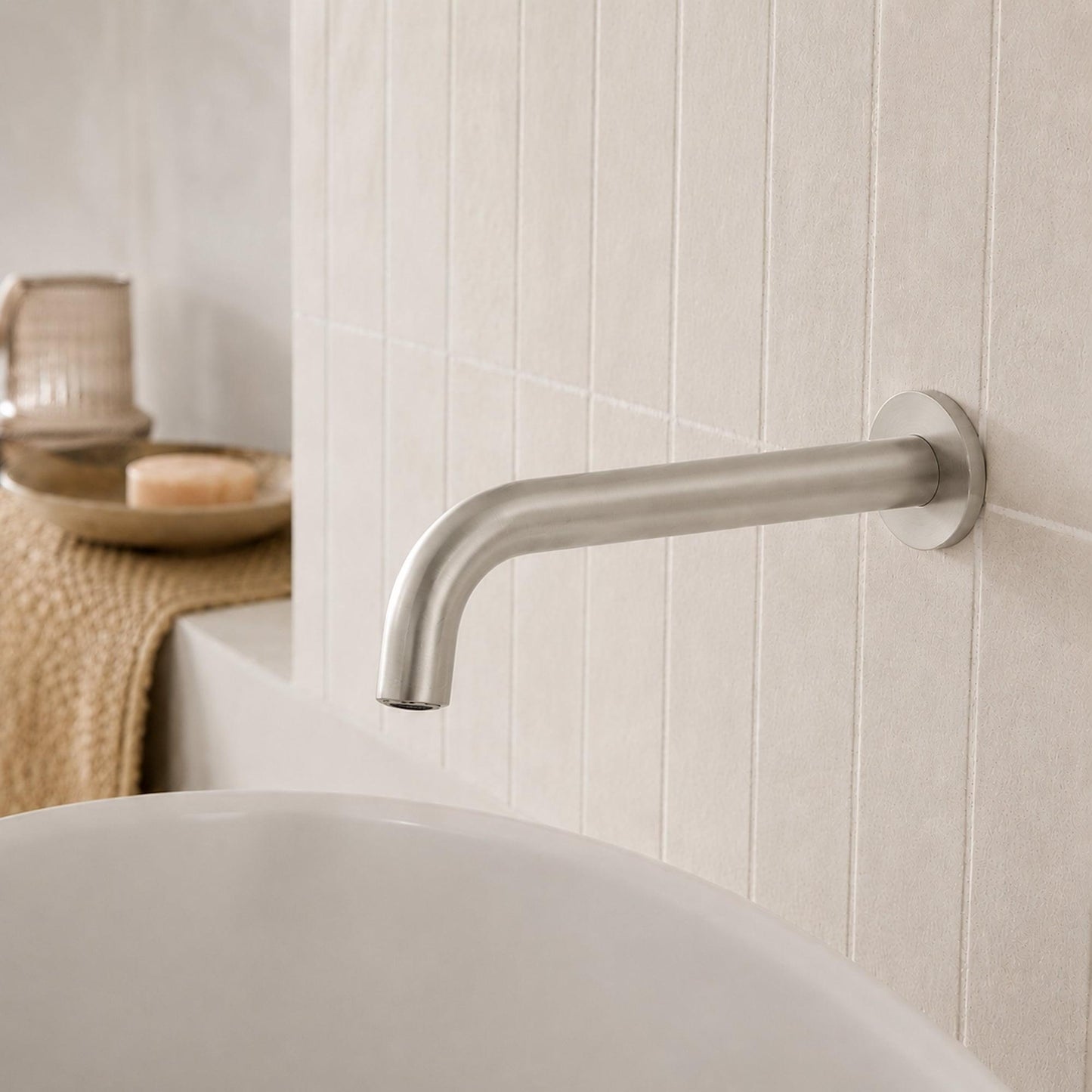 Brushed nickel wall spout with curved reach over sink