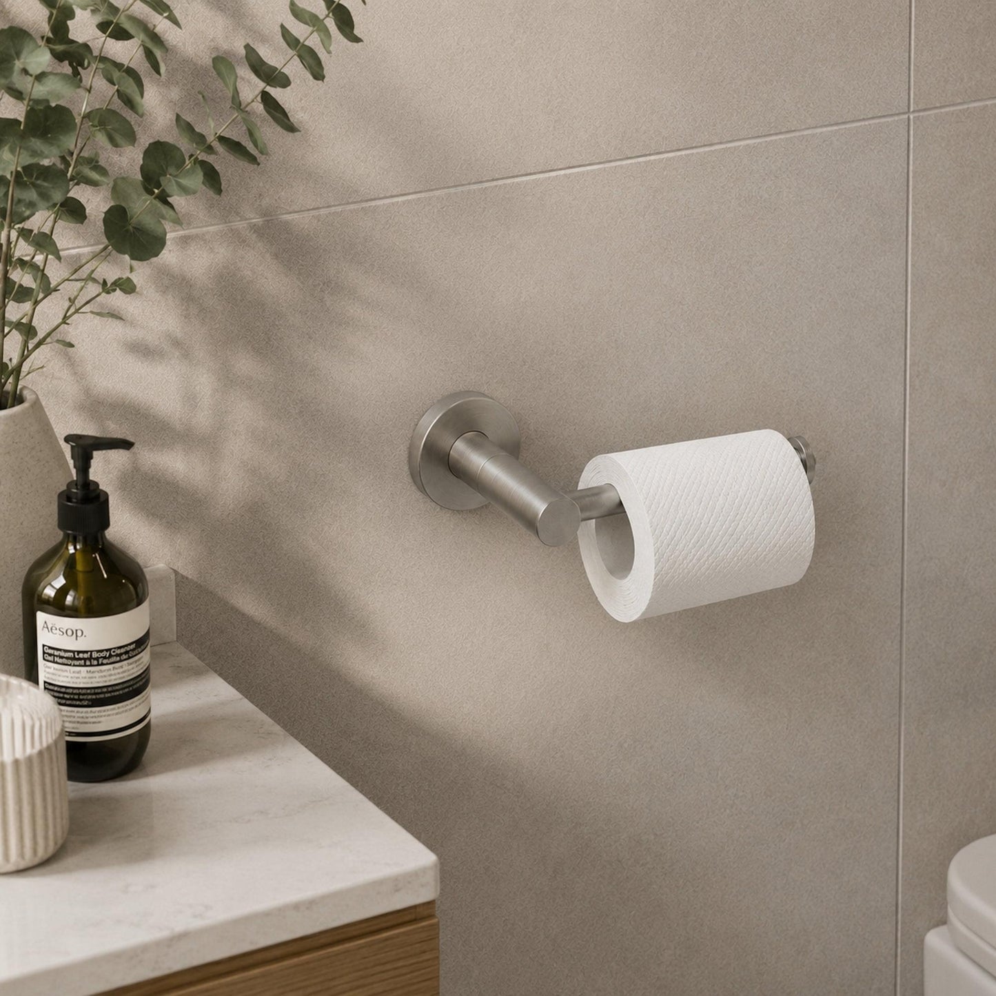 Brushed nickel toilet paper holder with built-in roll and circular wall mount