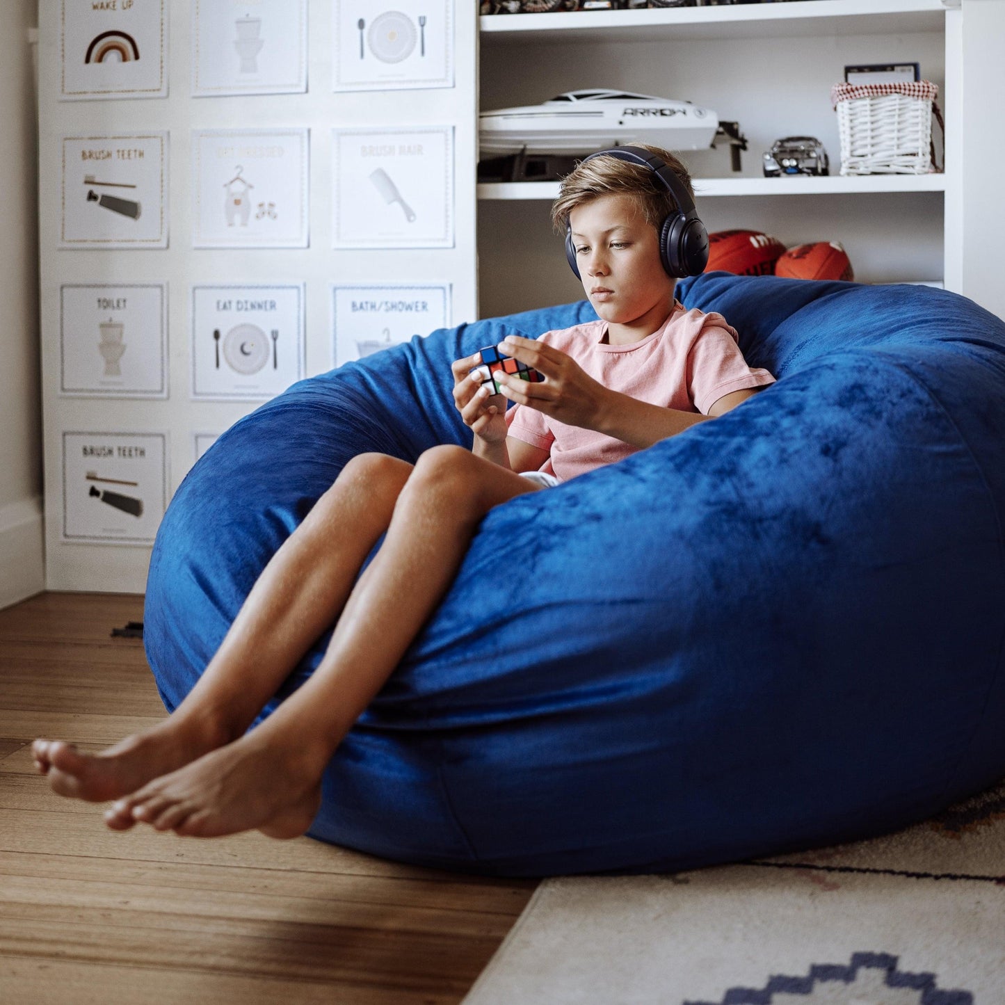 Ocean blue bean bag with fur-style upholstery as child rests with headphones