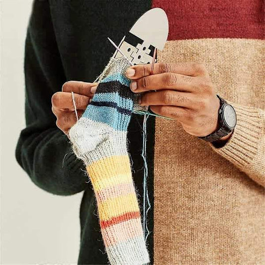 Adjustable wooden sock blocker holding a knitted sock during shaping.