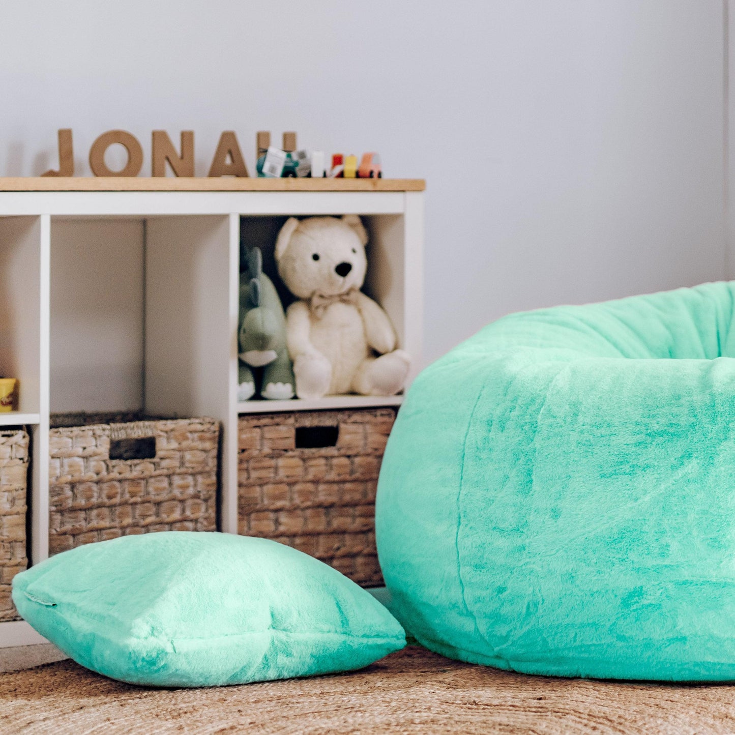 Turquoise plush fur cushion pillow, large close view of square cloud-like texture.