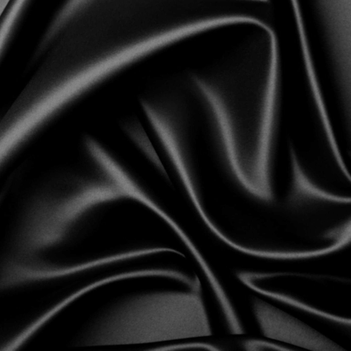 Black silky quilt cover fabric close-up, satin sheen and smooth drape
