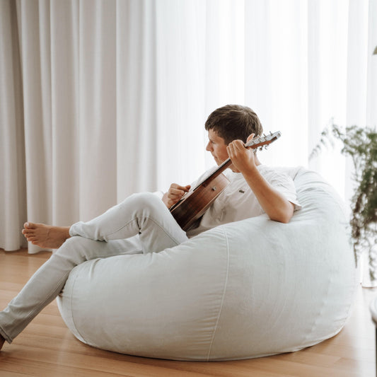 Light grey round bean bag seat with visible seams and tufted top