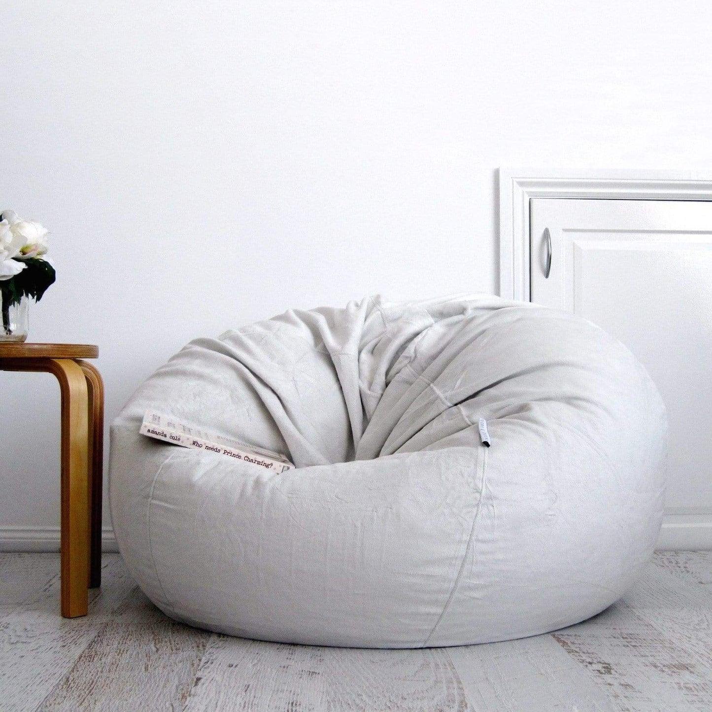 Silver grey round bean bag with stitched fabric panels and tufted top