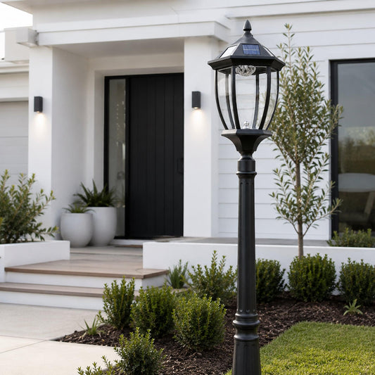 Black solar garden post light with clear lantern and solar panel, on patio