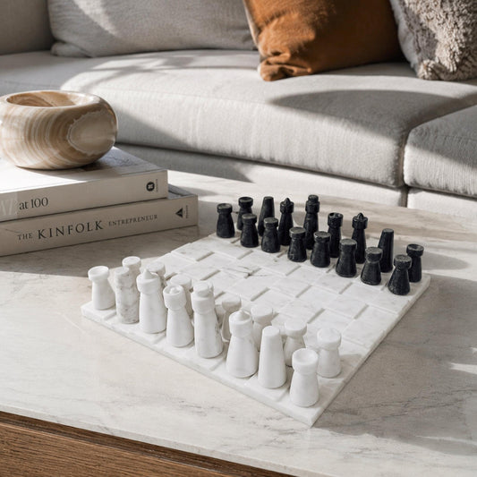 Marble-look chess board with white and dark gray pieces, angled view