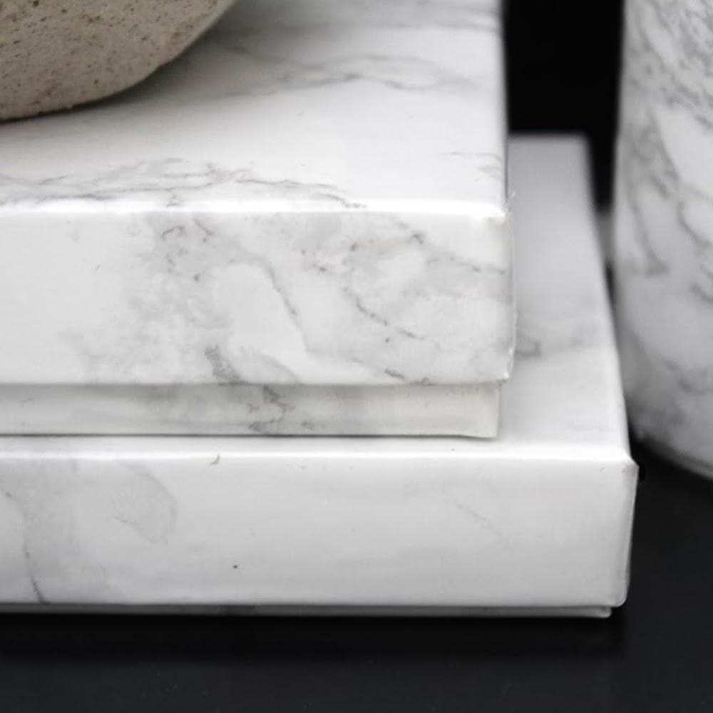 Wrapped gifts in white marble-pattern wrapping paper, close-up stack