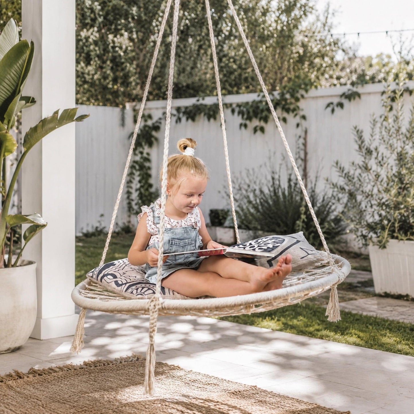 Cream macrame hanging hammock swing with circular woven seat and hanging cords