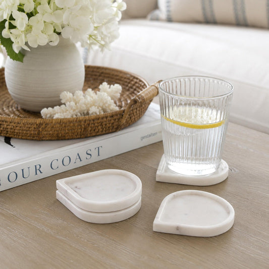 White marble raindrop coasters, three teardrop pieces on tabletop