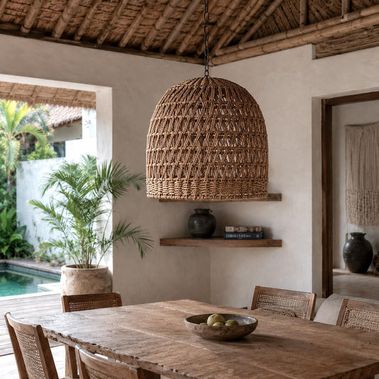Woven natural rope pendant light with domed open lattice shade hanging over dining area