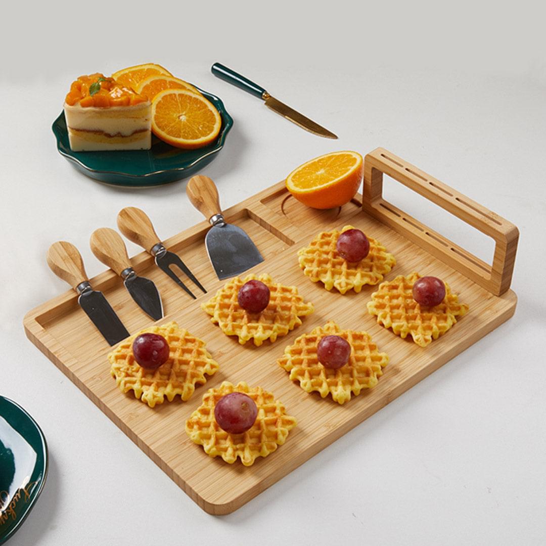 Rectangular wooden cheese board with four knives and knife rack, ready for charcuterie