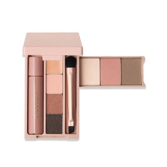 Pink mini makeup palette open with nude-toned eyeshadows, brow shade, and brush