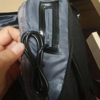 External charging cable module looped and tucked into backpack fabric pocket