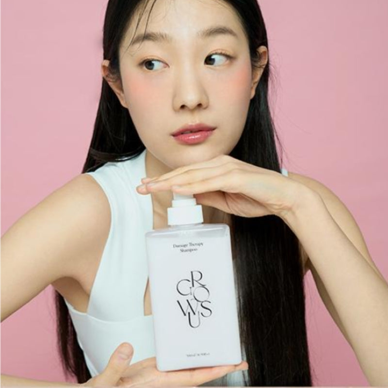 Rose-colored shampoo bottle with white pump held by woman, long dark hair