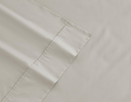 Light gray cotton sheet corner with stitched seam and hem detail