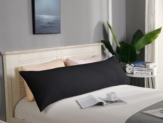 Black body pillowcase with smooth rectangular shape, laid on a bed